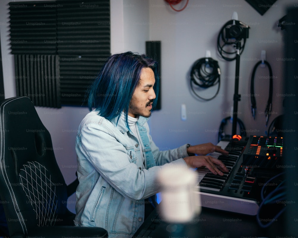 a man with blue hair playing a keyboard