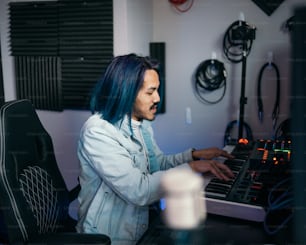 a man with blue hair playing a keyboard