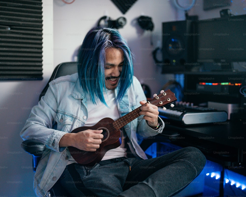 a man with blue hair playing a guitar