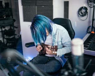 a person with blue hair sitting in a chair
