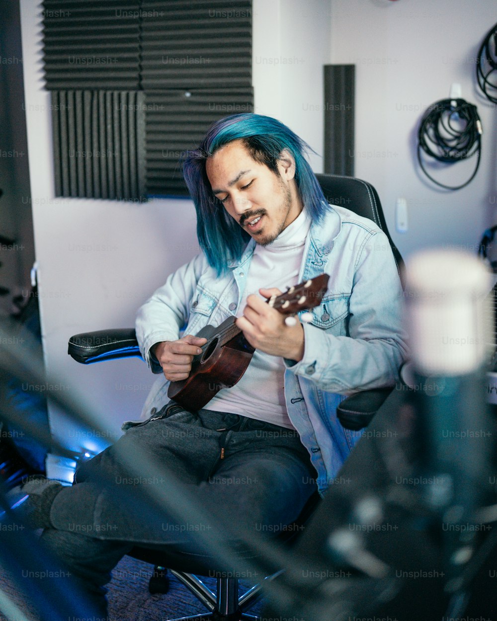 a man with blue hair playing a guitar