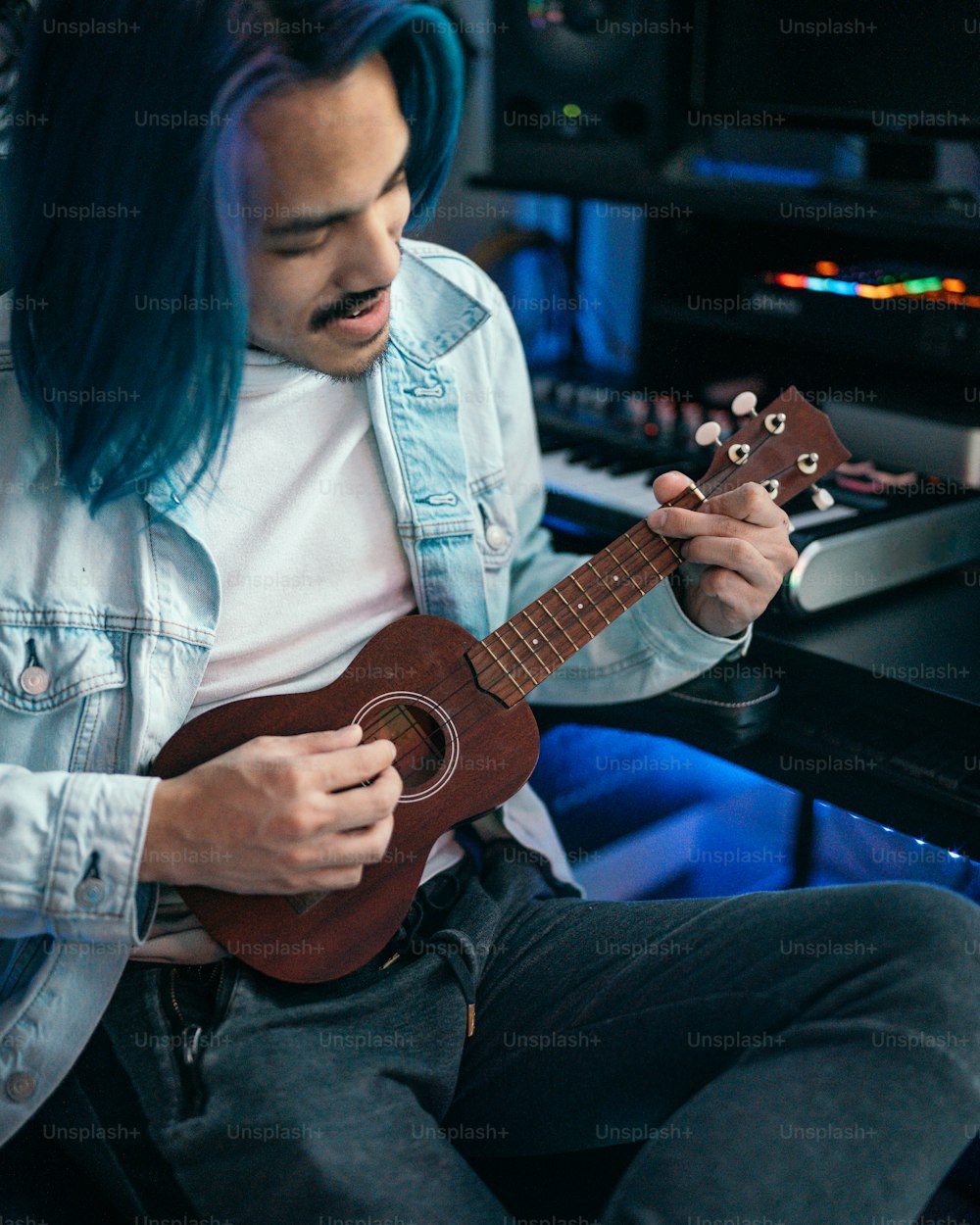 a man with blue hair playing a ukulele