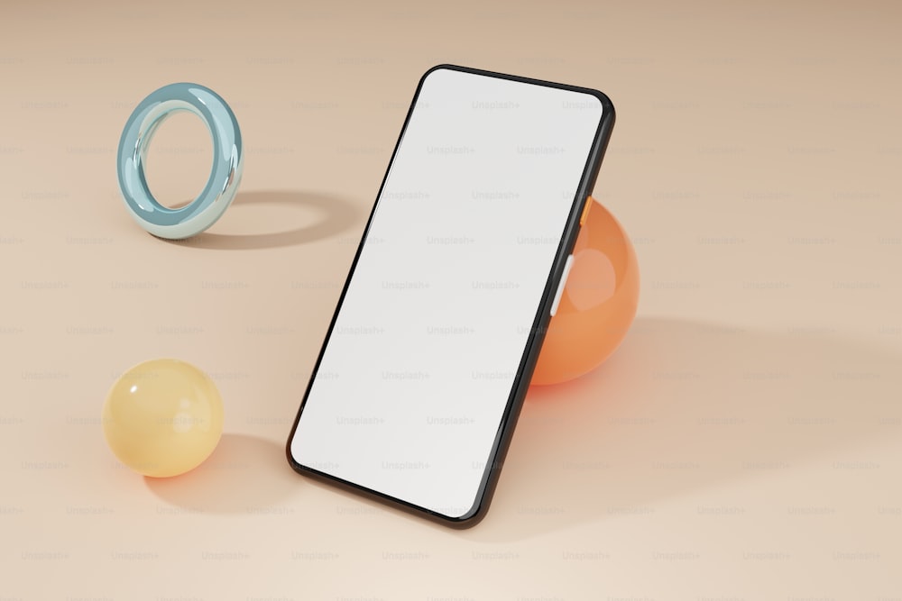 Un teléfono celular sentado encima de una mesa junto a una bola naranja