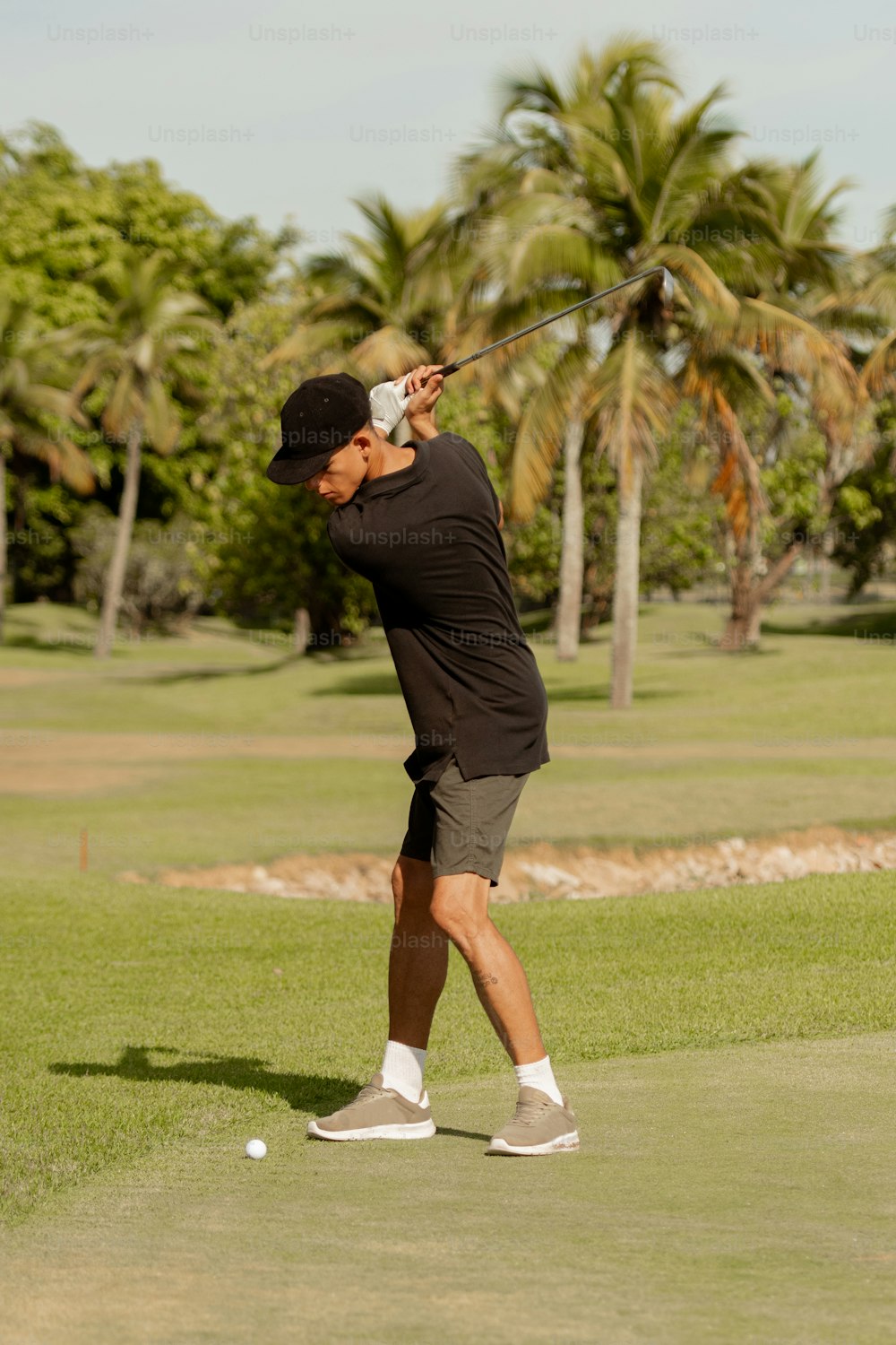 a man swinging a golf club on a golf course