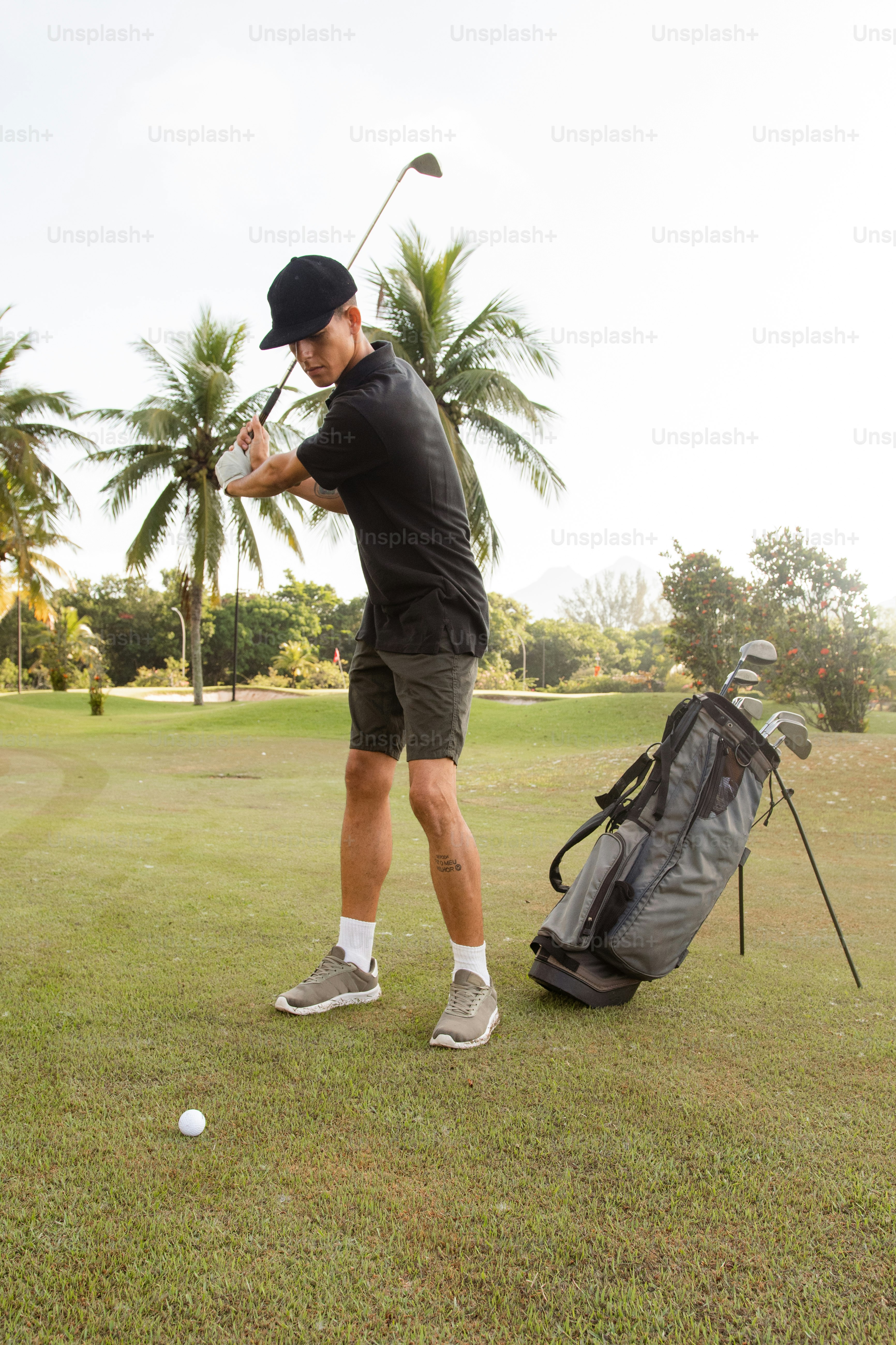 Un homme frappant une balle de golf avec un club de golf