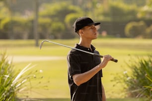a young man holding a golf club in his hand