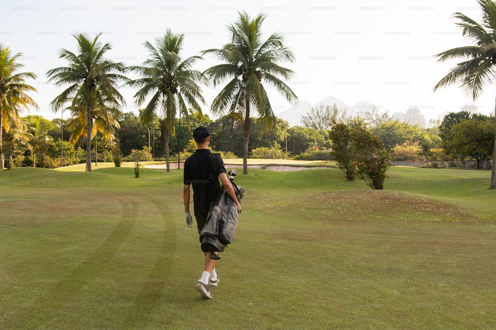 a man walking across a lush green field