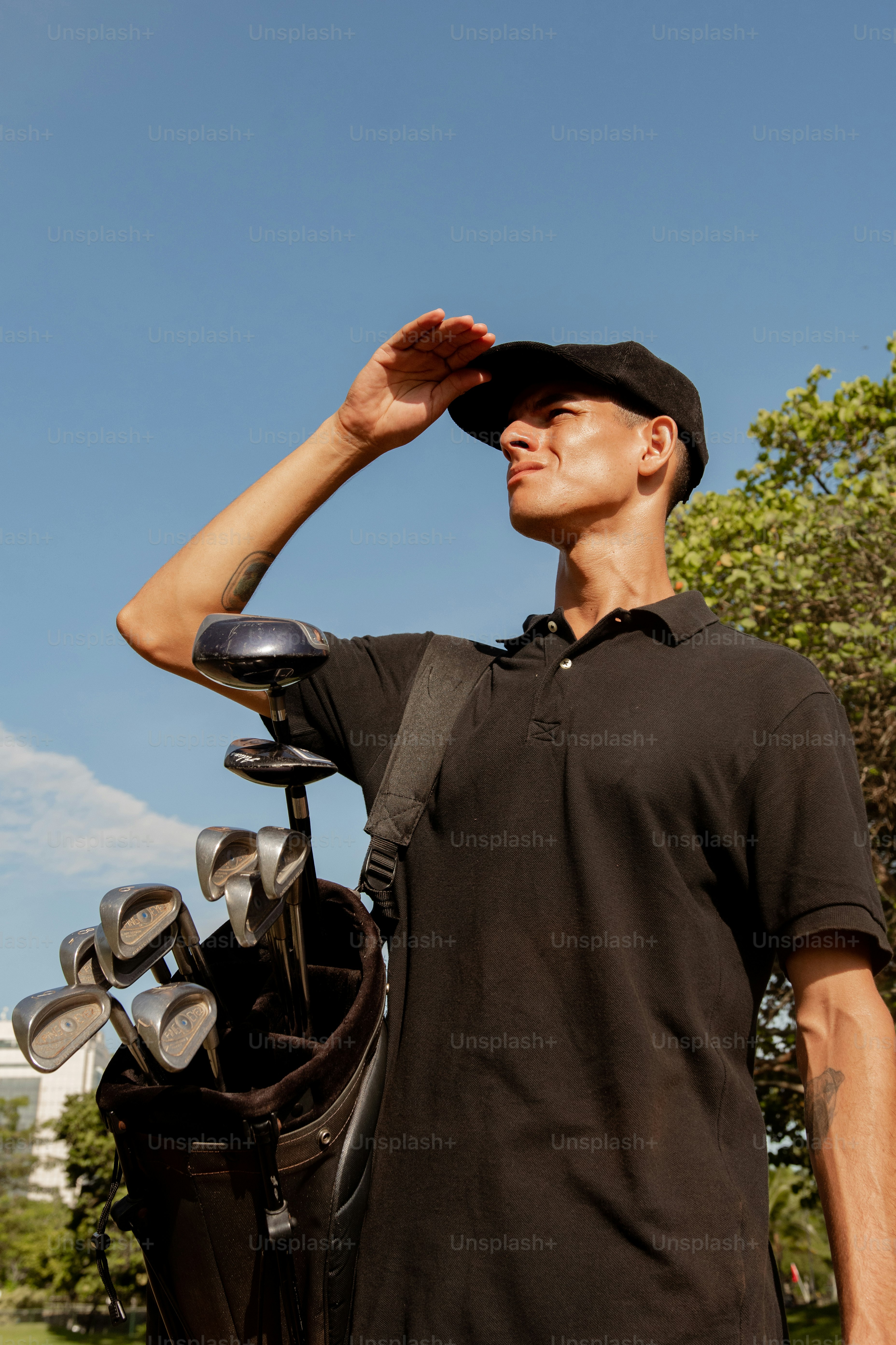 Un homme tenant un club de golf et le mettant dans son chapeau