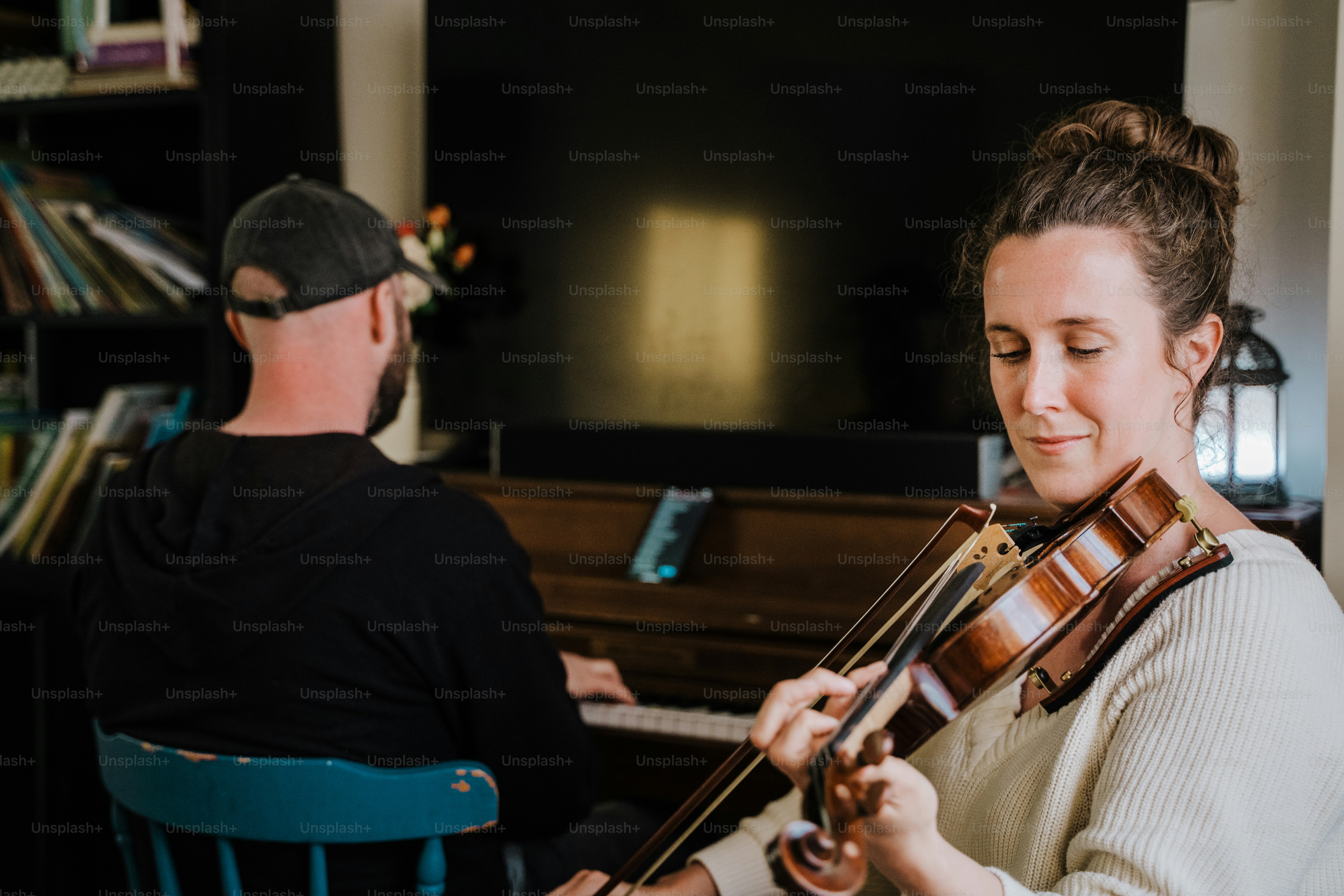 a man and a woman playing violin in a living room