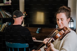 Ein Mann und eine Frau spielen Geige in einem Wohnzimmer