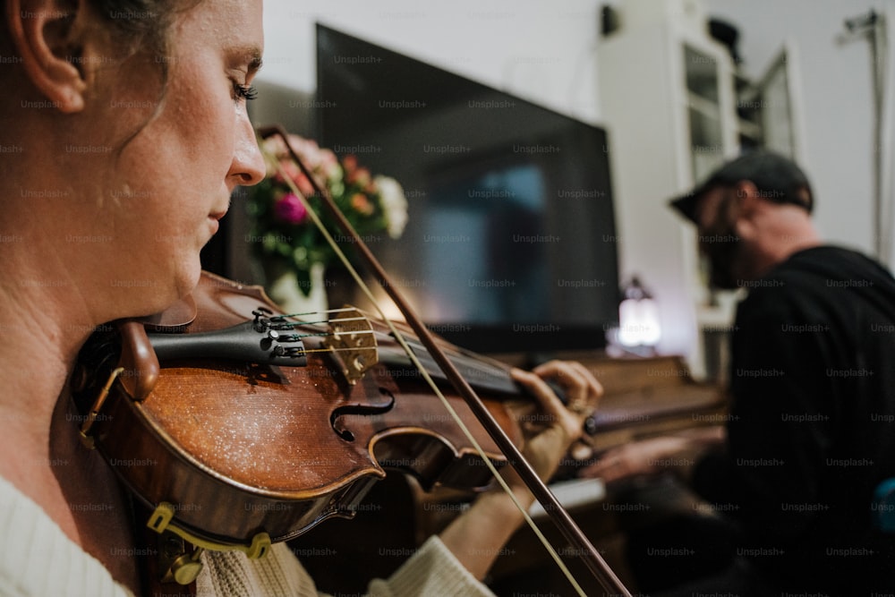 Una mujer tocando un violín frente a un hombre