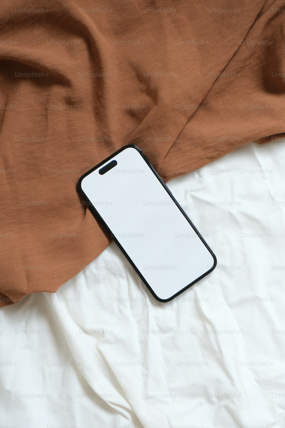 a cell phone laying on top of a bed