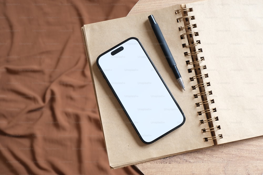 a notepad and pen on a notebook on a bed