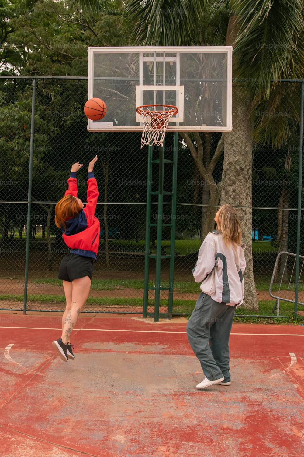 Zwei Personen spielen Basketball auf einem Basketballplatz