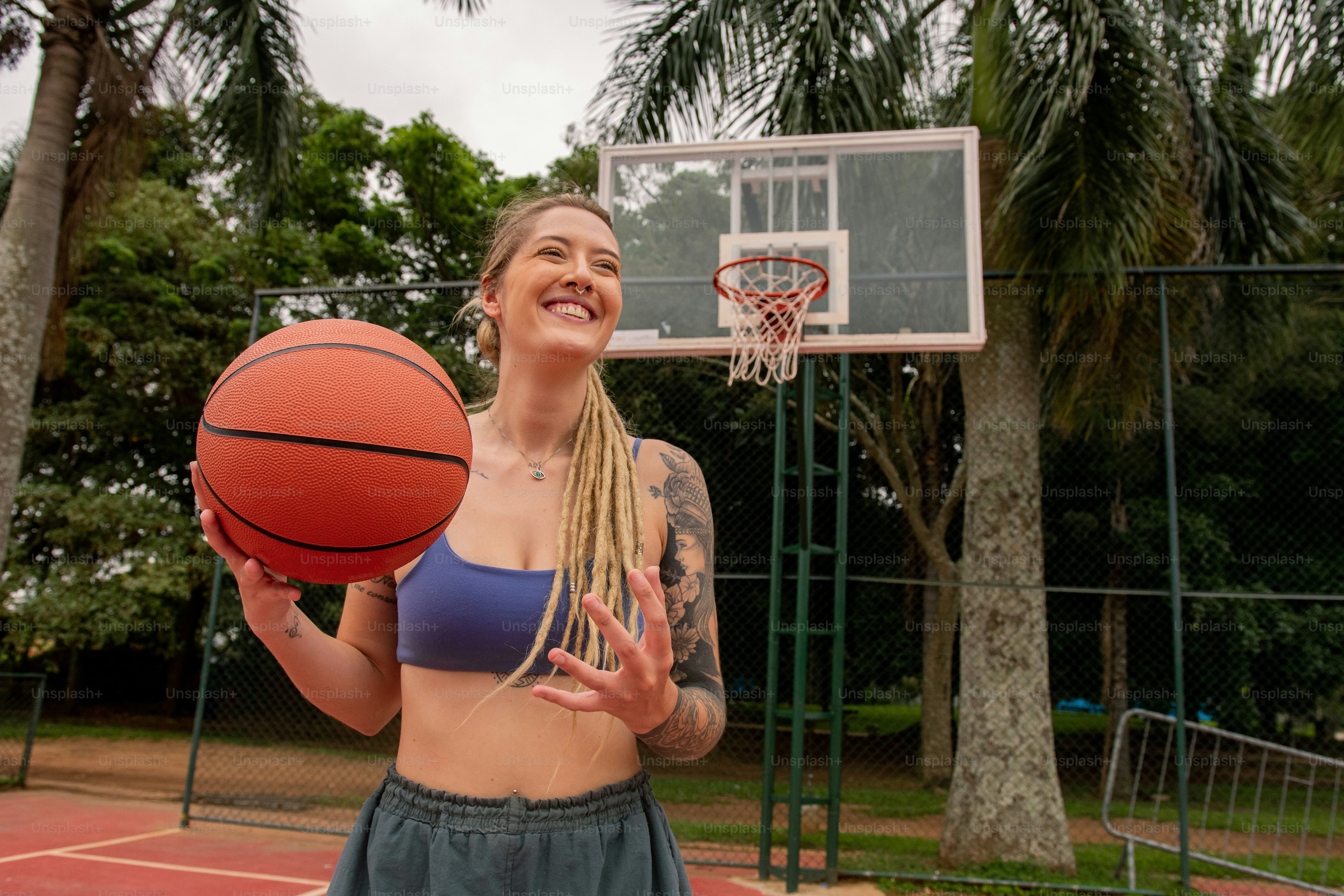 a woman holding a basketball on a basketball court