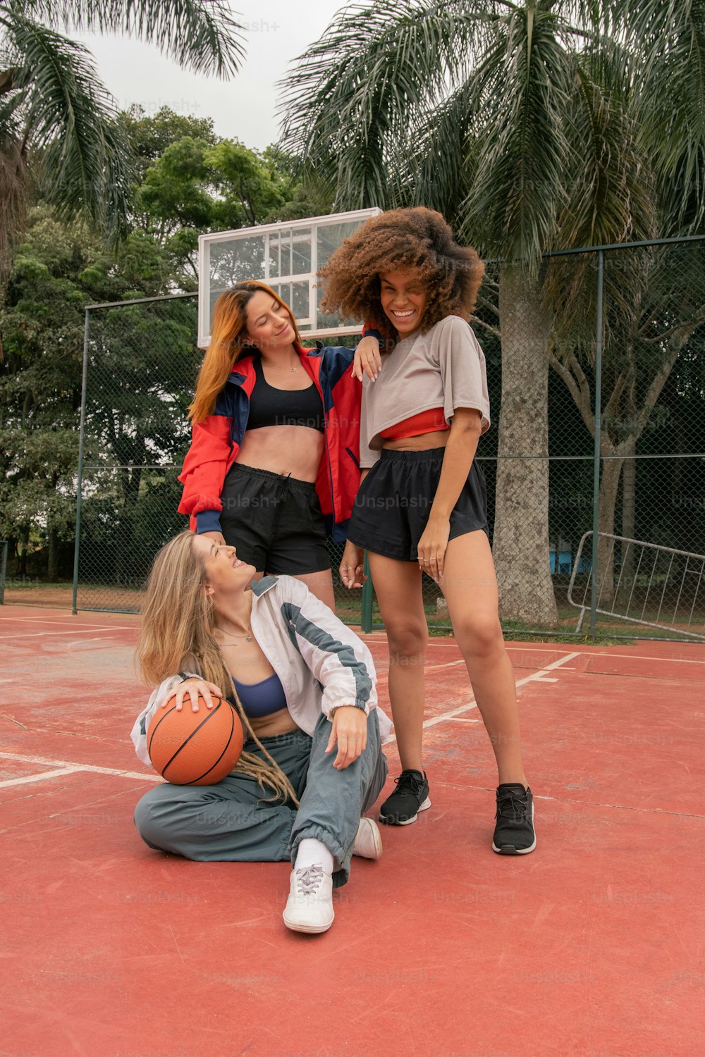 a group of young women standing on top of a basketball court
