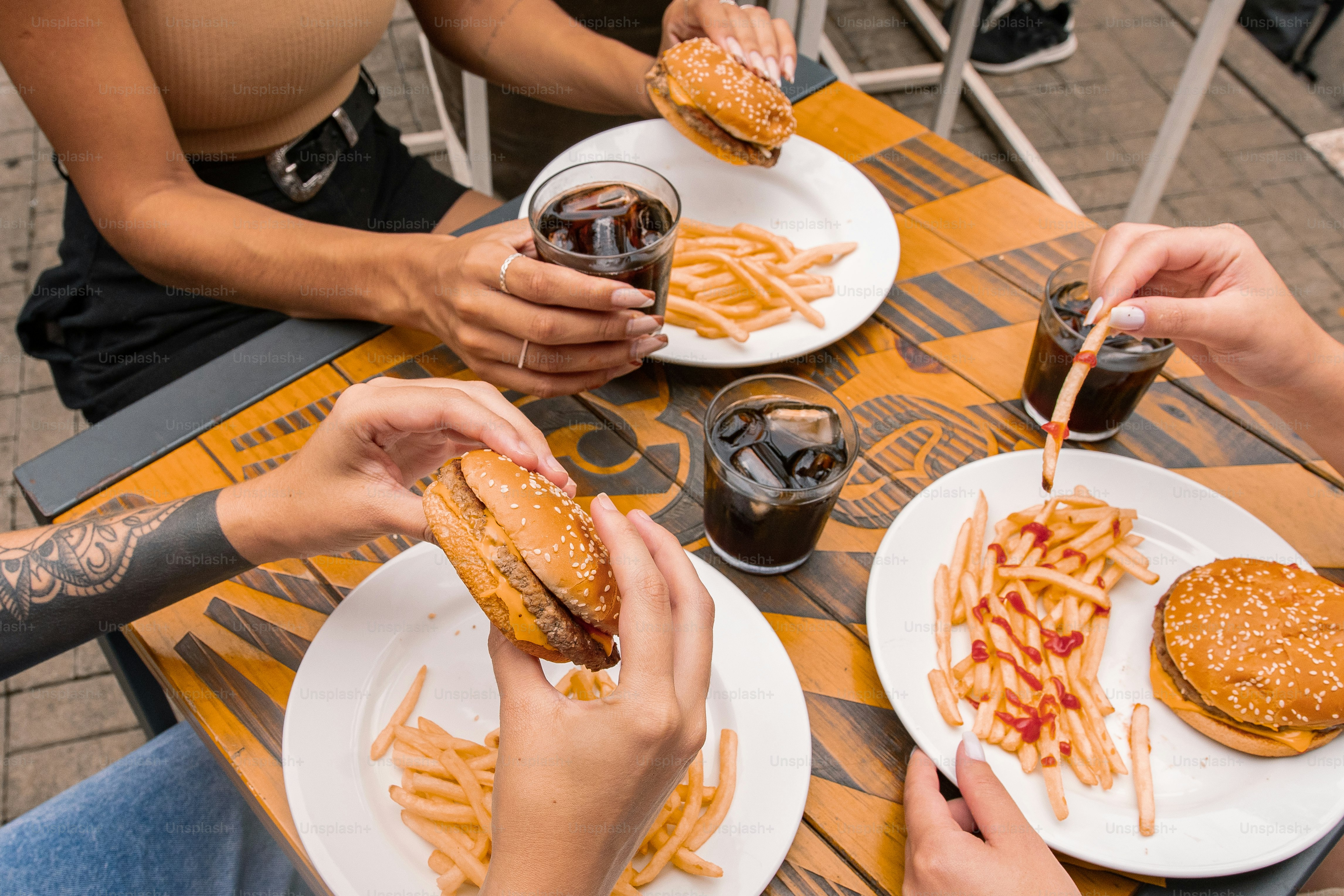 Eine Gruppe von Menschen, die an einem Tisch mit Tellern mit Essen sitzen