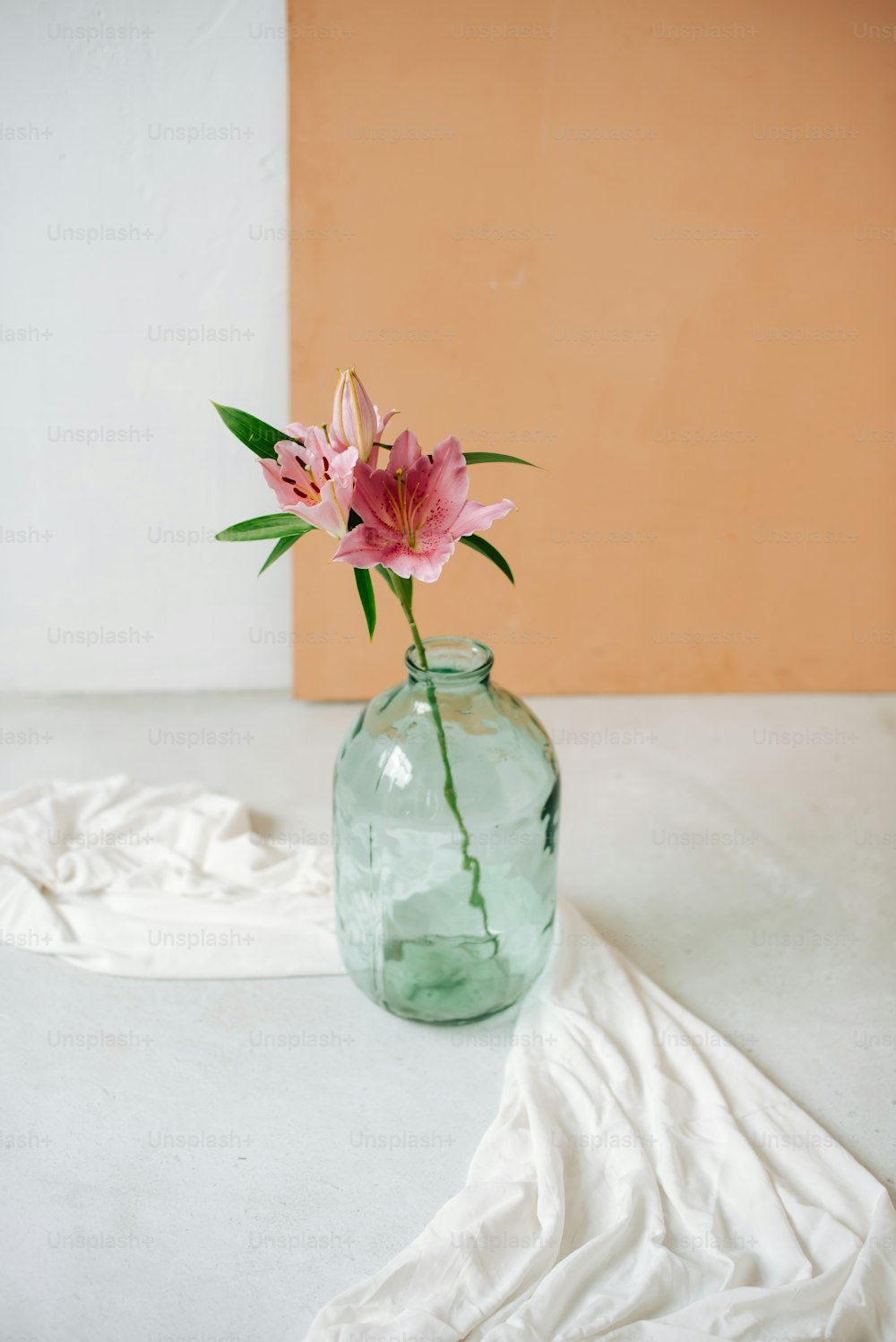 un fiore rosa in un vaso di vetro su un tavolo