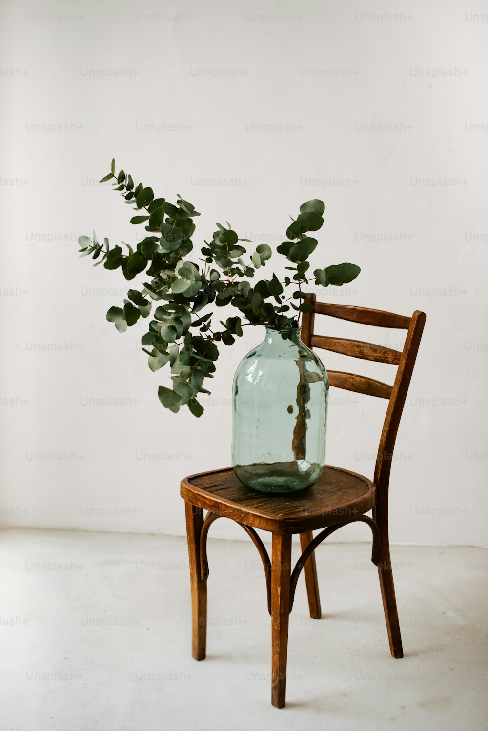 a wooden chair with a vase on top of it