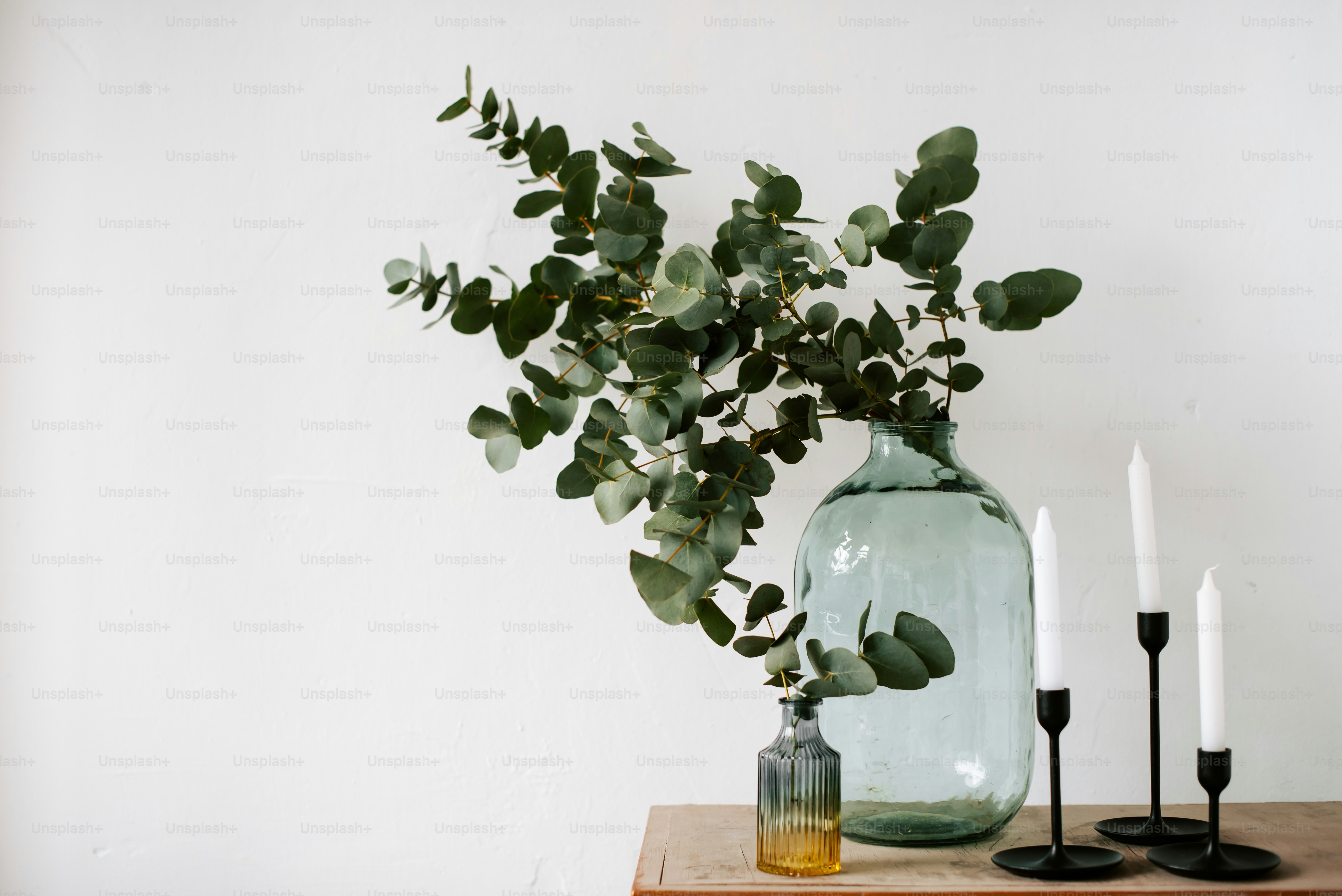 a wooden table topped with two vases filled with plants