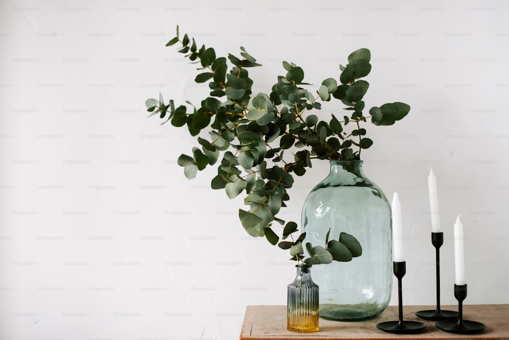 ein Holztisch mit zwei Vasen, die mit Pflanzen gefüllt sind