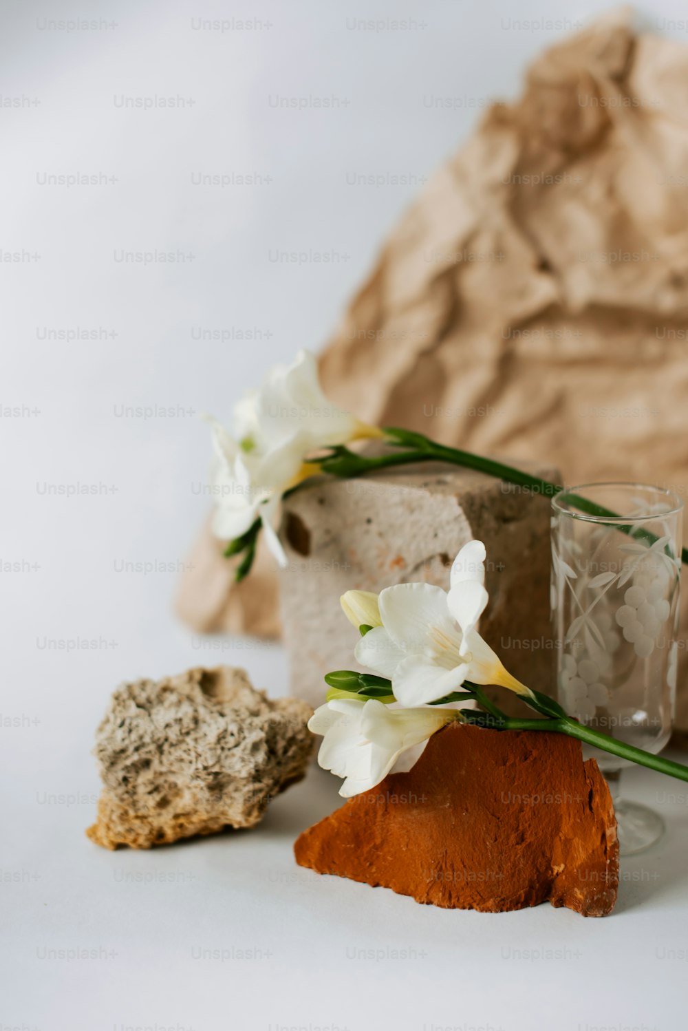 a table topped with a vase filled with flowers next to a rock