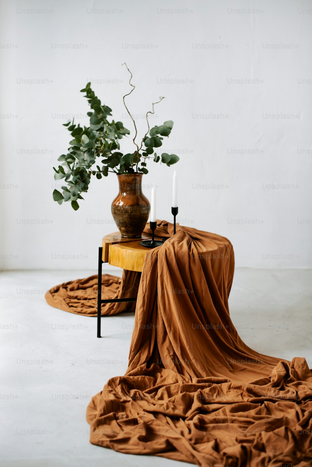a table topped with a vase filled with a plant