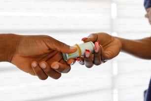Una mujer sosteniendo un pequeño tubo de pasta de dientes en la mano