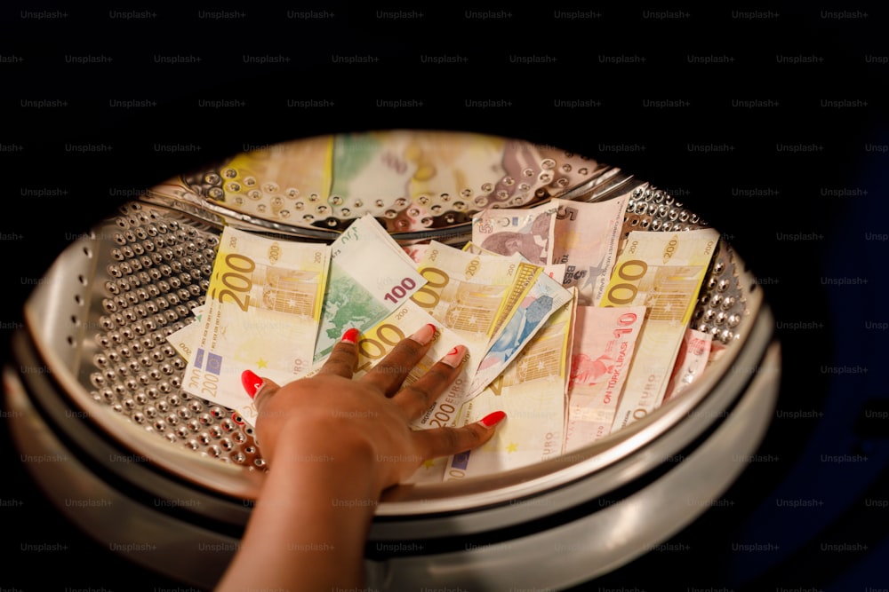 a woman's hand reaching for a stack of money
