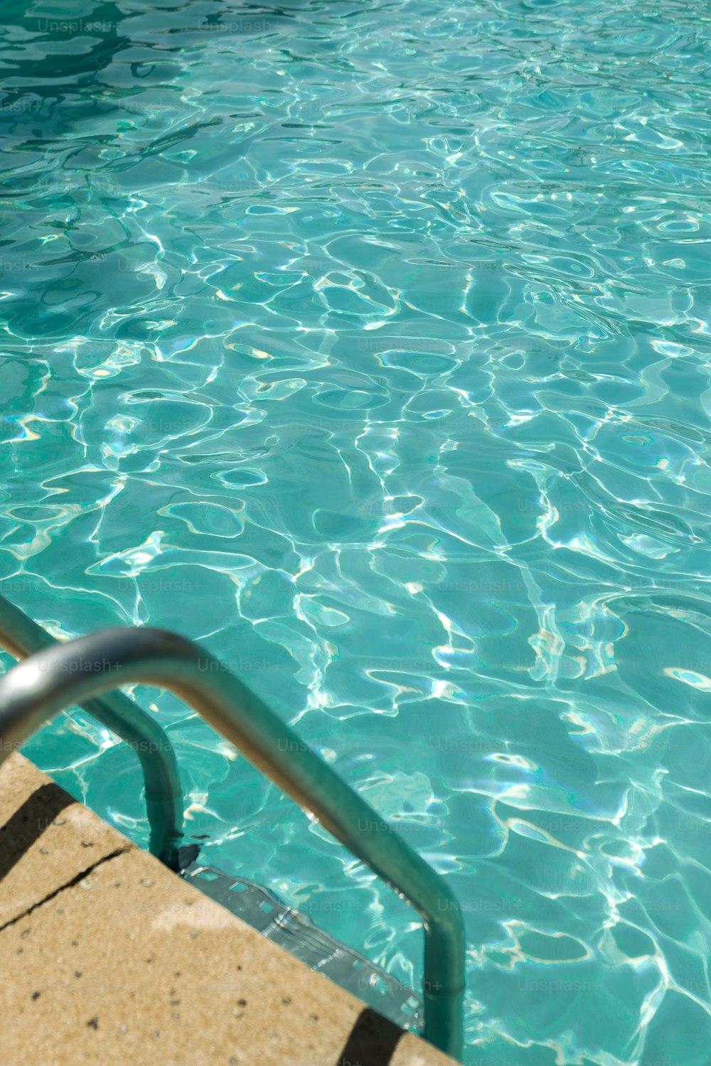 a pool with clear blue water and a metal hand rail