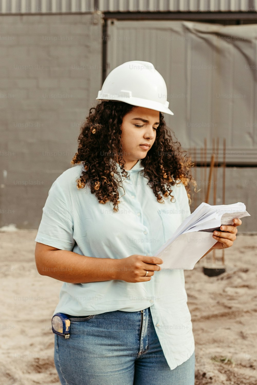 a woman in a hard hat reading a piece of paper