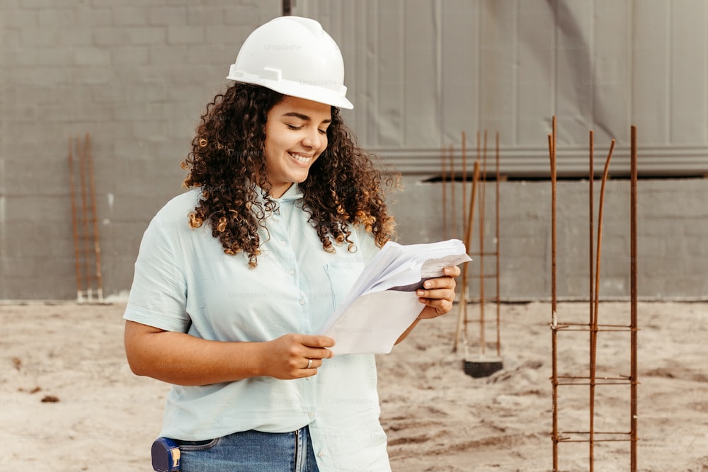 a woman in a hard hat looking at a piece of paper