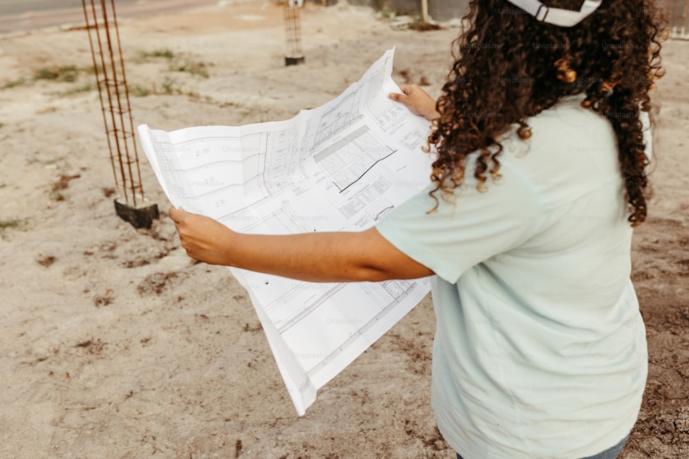 a woman holding a blueprint in her hands