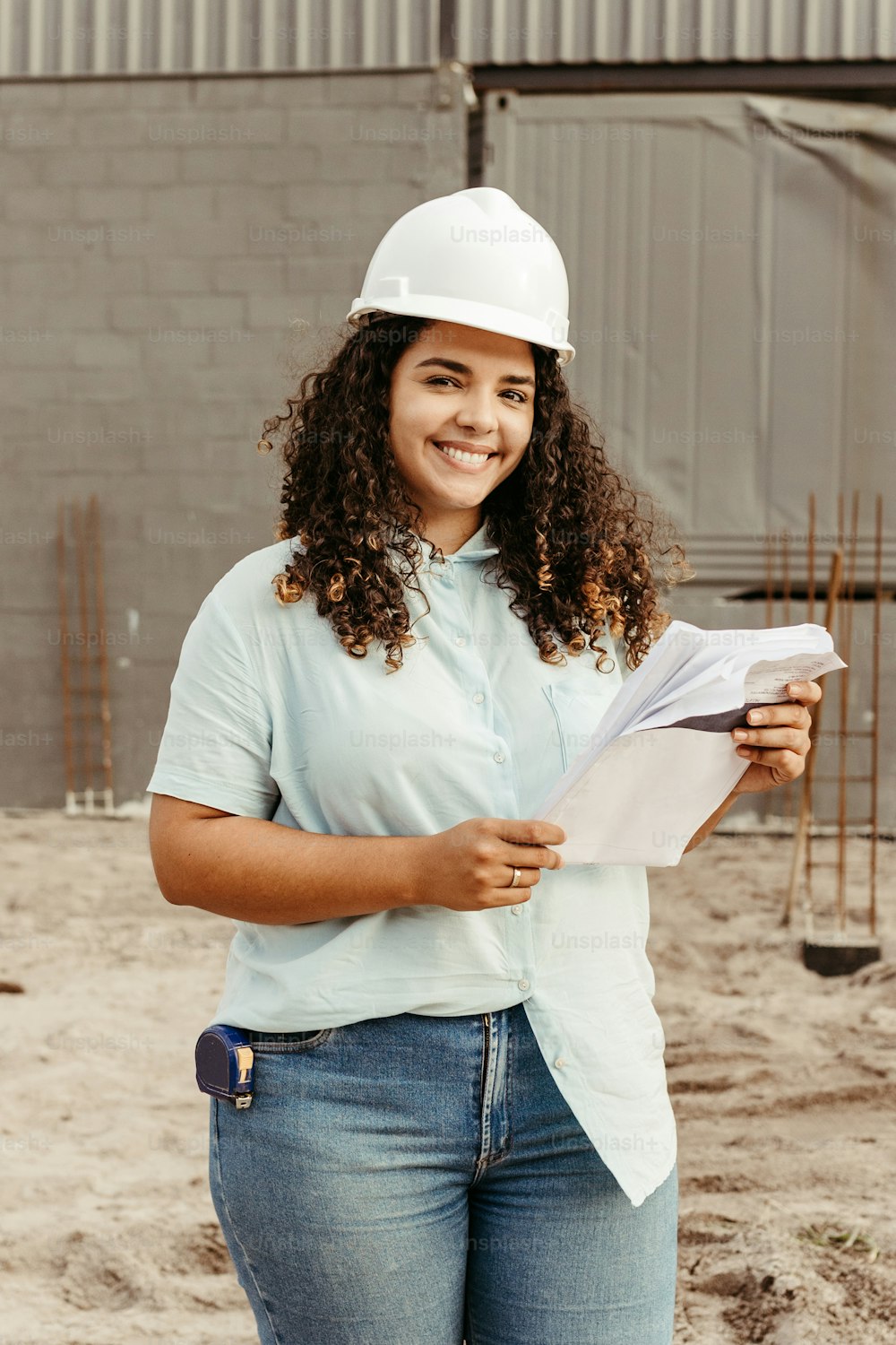 a woman in a hard hat holding a piece of paper