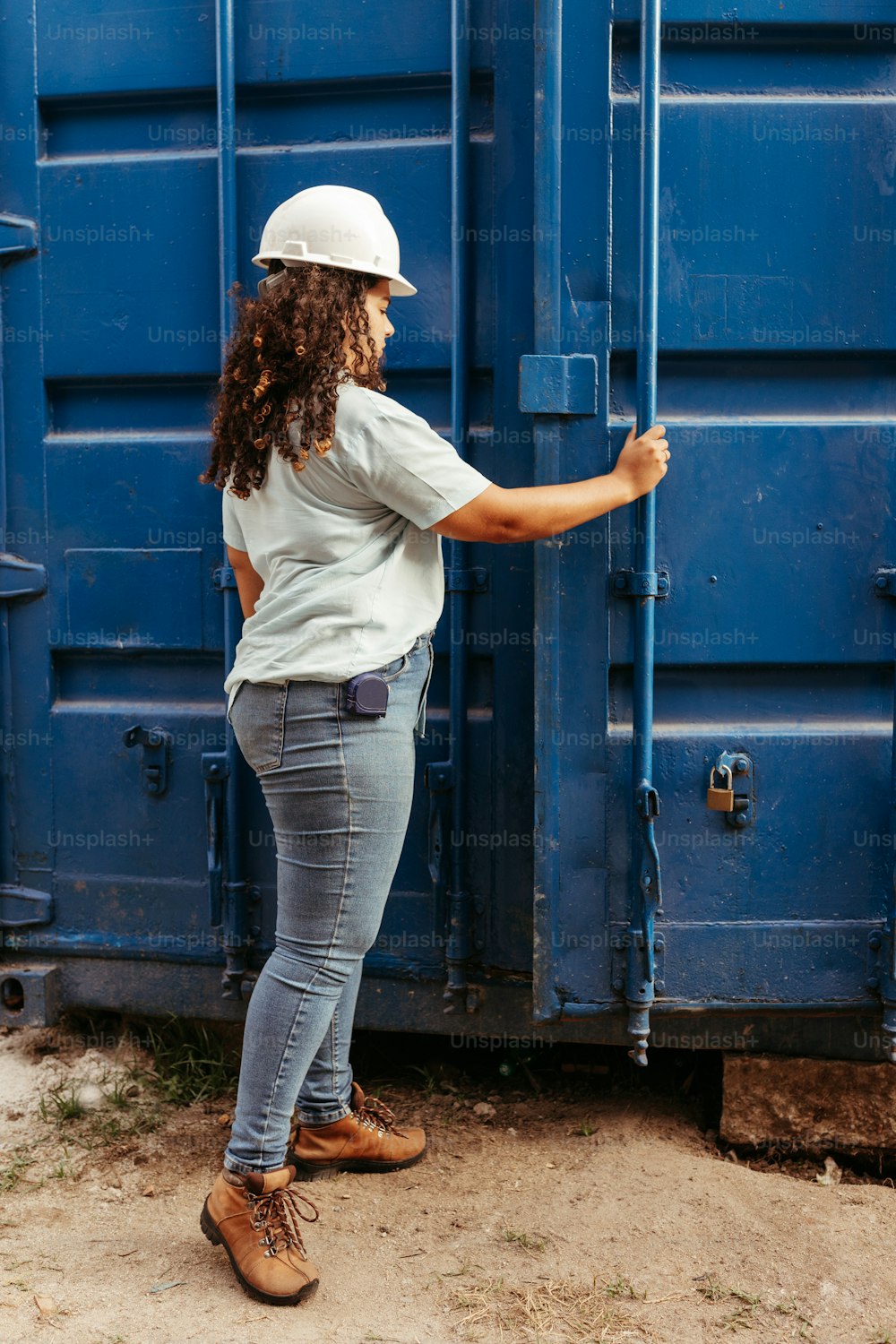 青い容器の前に立つ女性