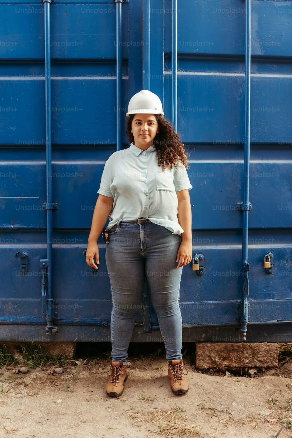 uma mulher em pé na frente de um recipiente azul