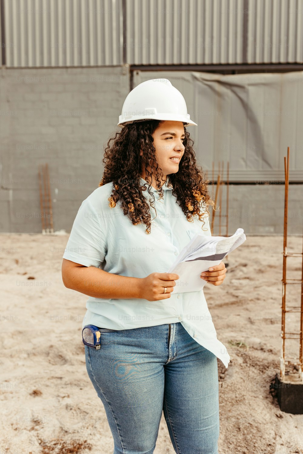 a woman wearing a hard hat and holding a piece of paper