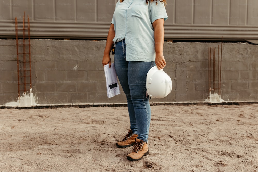 a woman standing in the sand holding a white frisbee