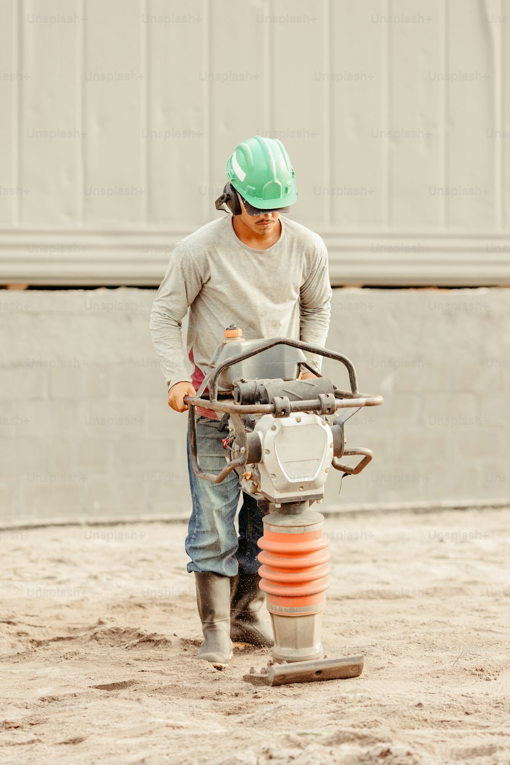 a man in a hard hat is using a machine