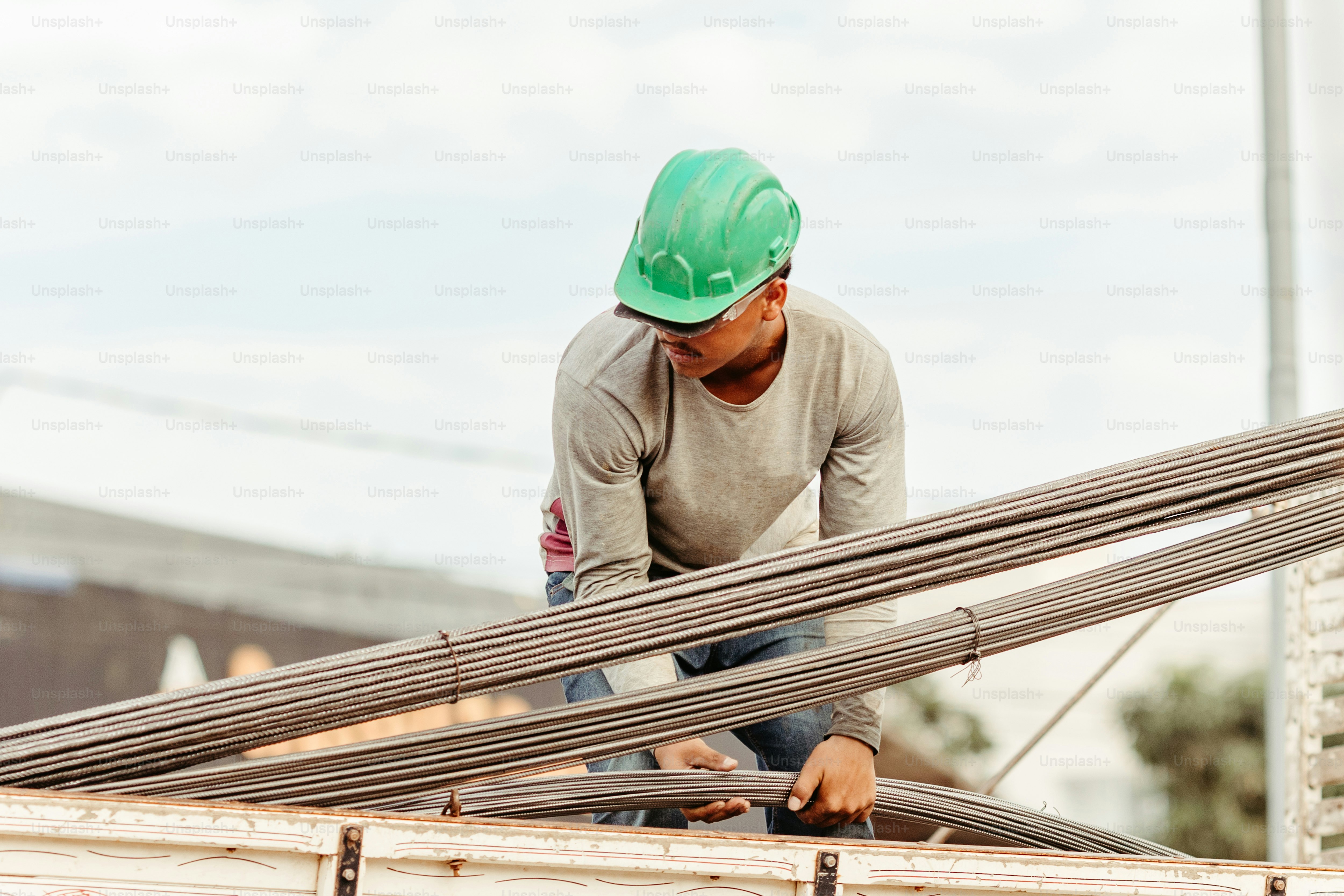 a man in a green hard hat working on a building