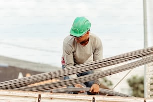a man in a green hard hat working on a building