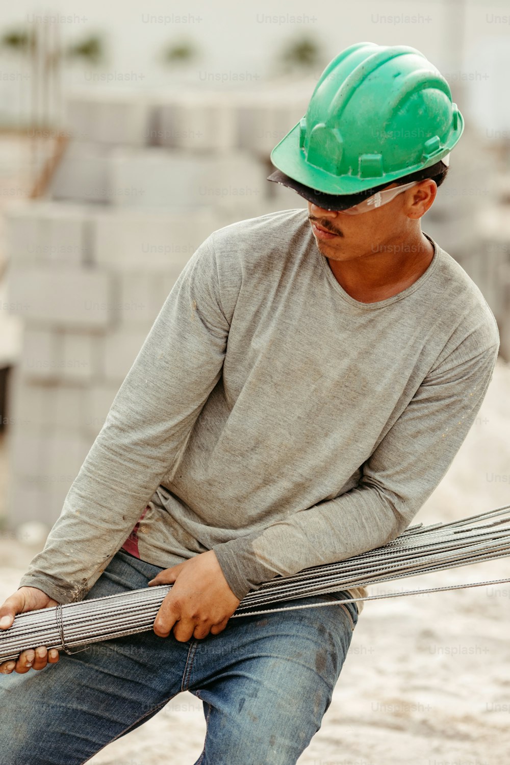 a man wearing a hard hat and holding a piece of metal