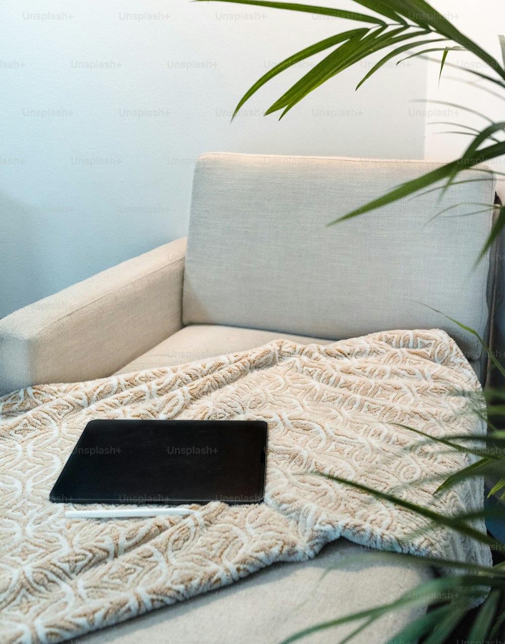 un ordinateur portable posé sur une couverture sur un canapé