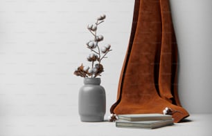 un vase avec une plante à côté d’un livre