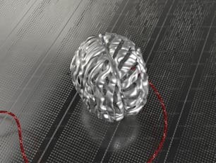 una palla di filo che si trova sopra una superficie metallica