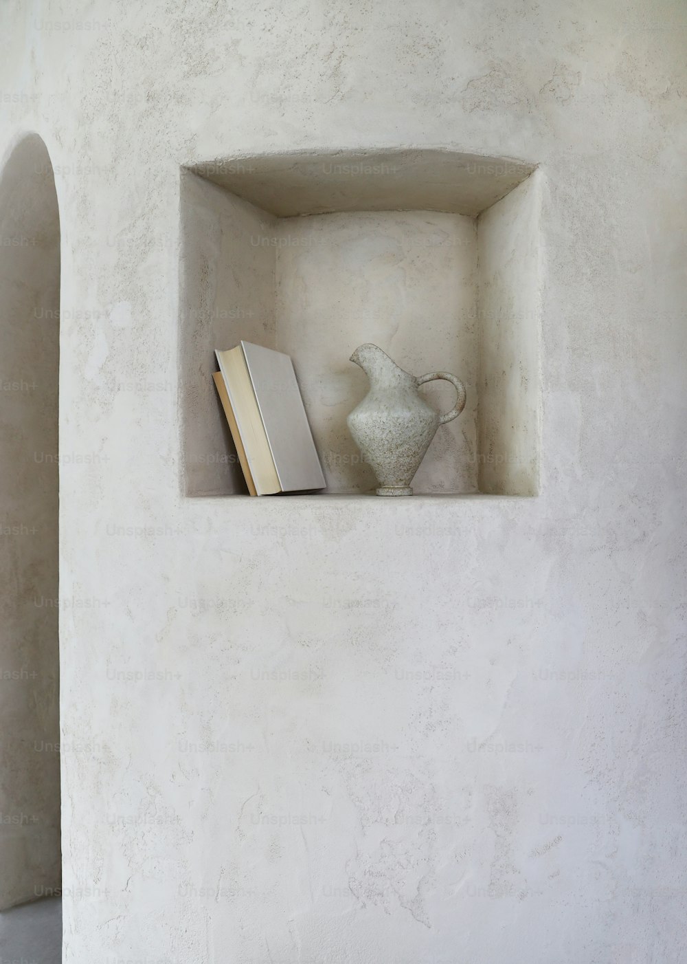 Un libro è seduto su uno scaffale con un vaso
