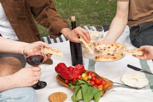a group of people sitting around a table with food and wine