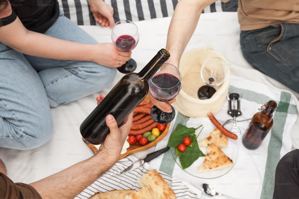 a group of people sitting around a table with food and wine