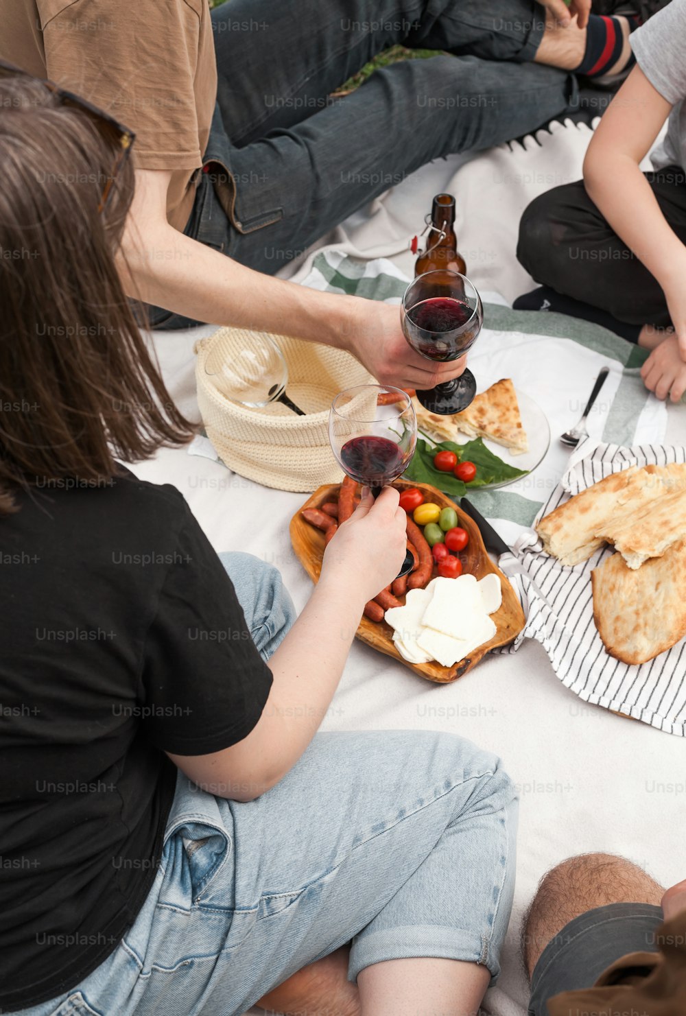 um grupo de pessoas sentadas ao redor de uma mesa com alimentos e bebidas