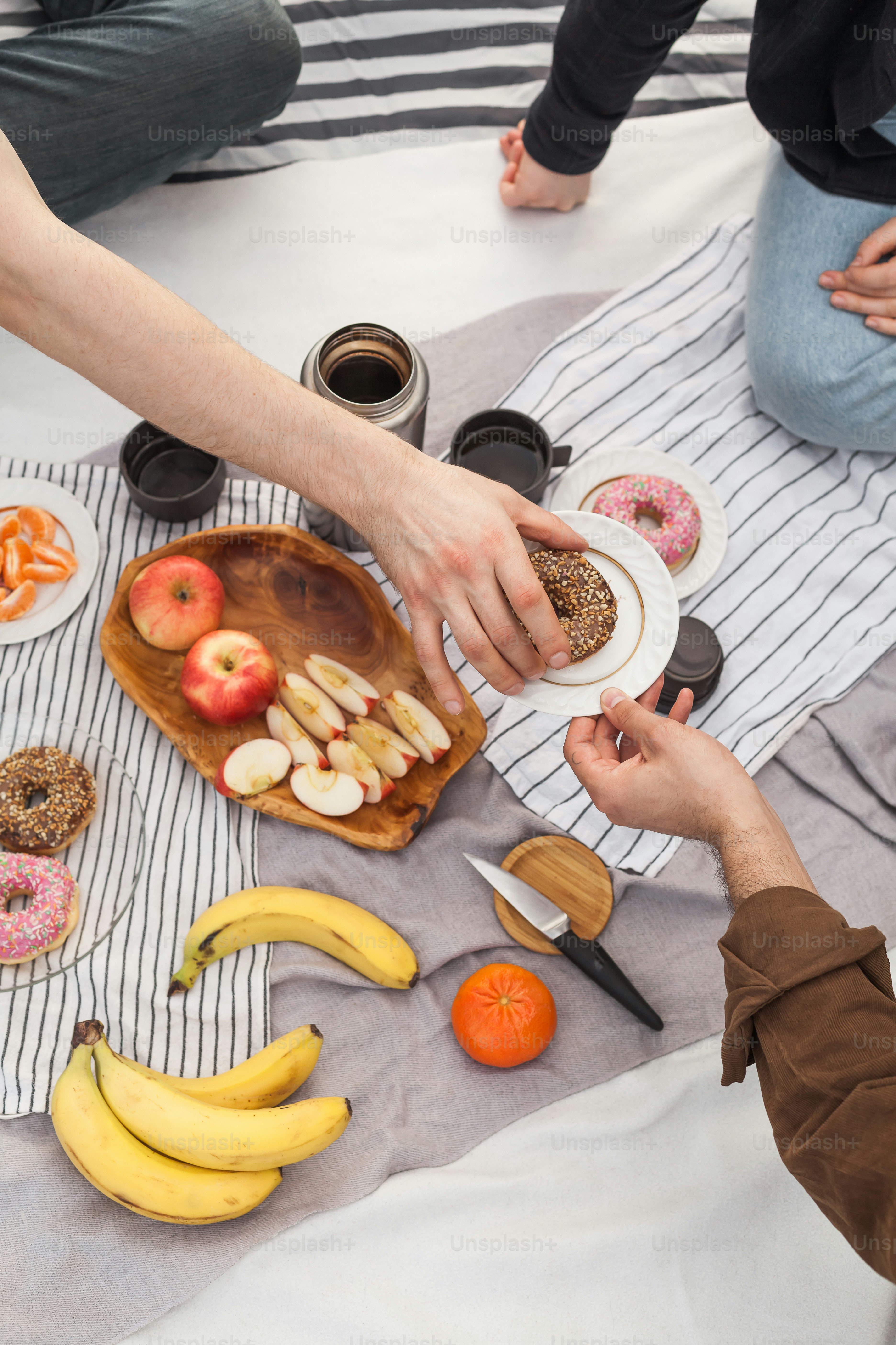 A group of people sitting around a table with food and wine photo ...